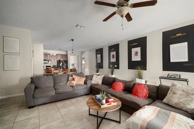 a living room with furniture and a ceiling fan