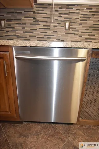 a kitchen with stainless steel appliances granite countertop a sink a refrigerator a washer and dryer