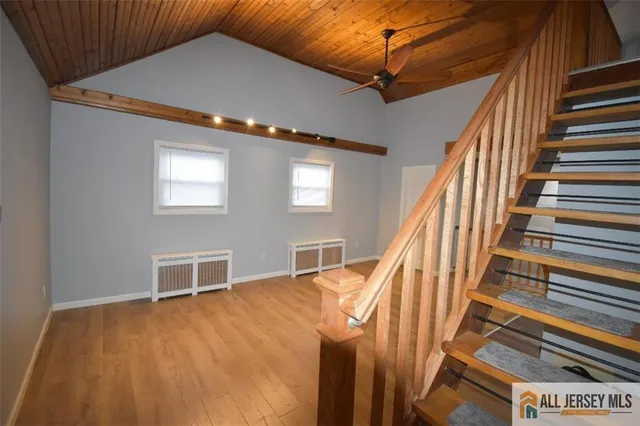 a view of a livingroom with wooden floor and stairs