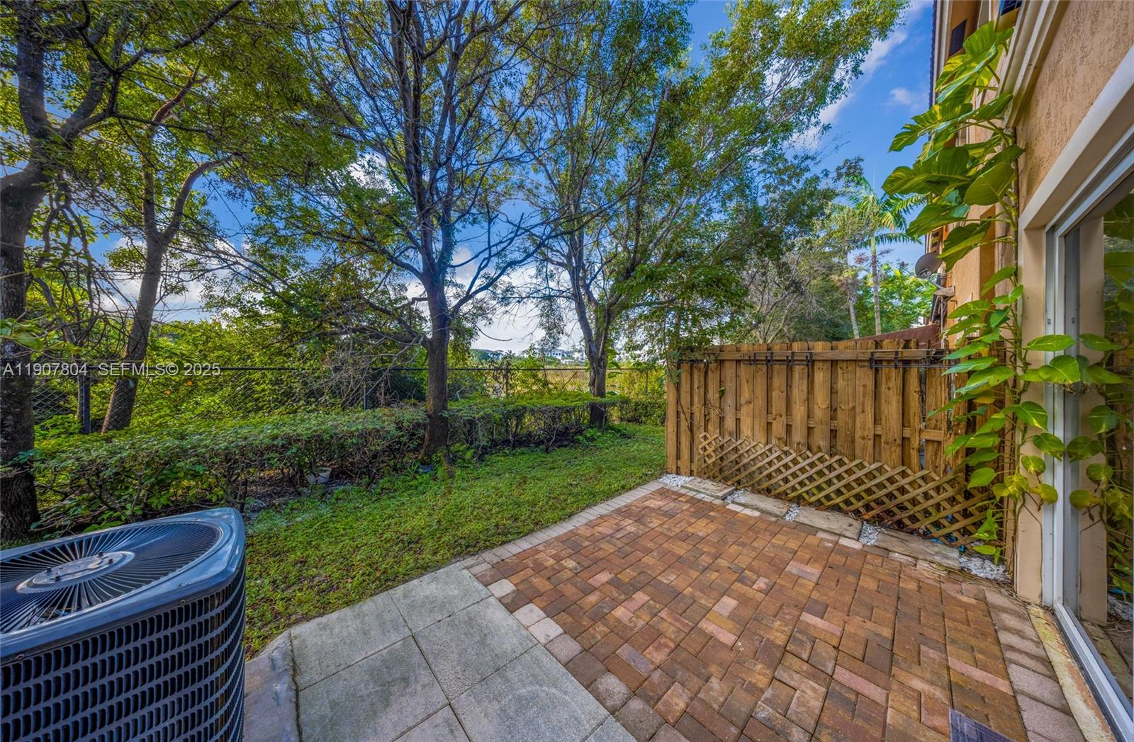 12040 Southwest 28th Street, Unit 4064 Miramar, FL 33025 - Photo 18 of 19 a view of a backyard with a large tree