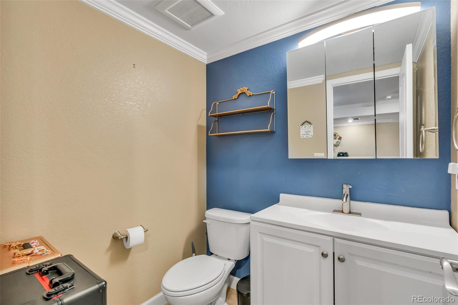 3198 South Nepal Way Aurora, CO 80013 - Photo 30 of 44 a bathroom with a toilet a sink and mirror