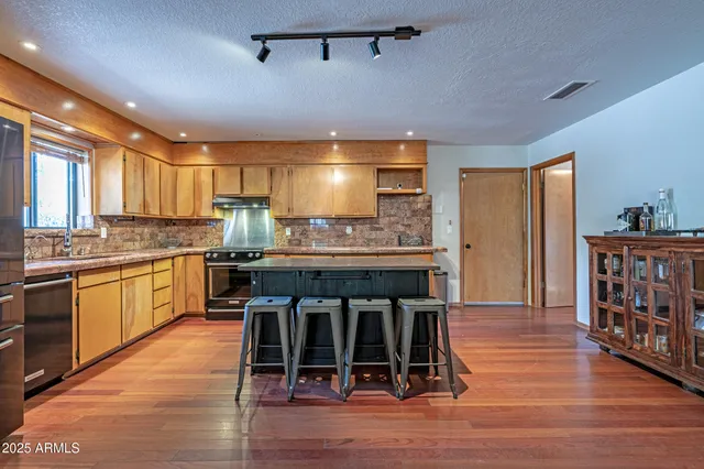 a kitchen with stainless steel appliances granite countertop wooden floors and sink