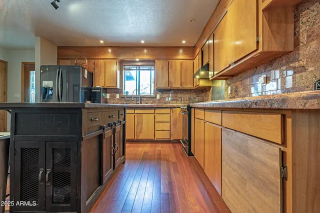 a kitchen with granite countertop a sink stove and cabinets