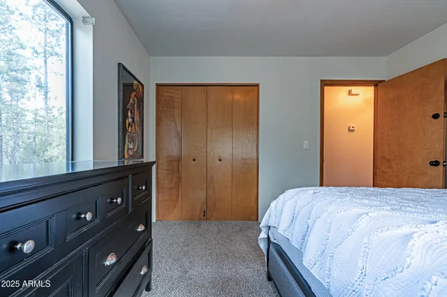 a bedroom with a bed and a flat tv screen on dresser