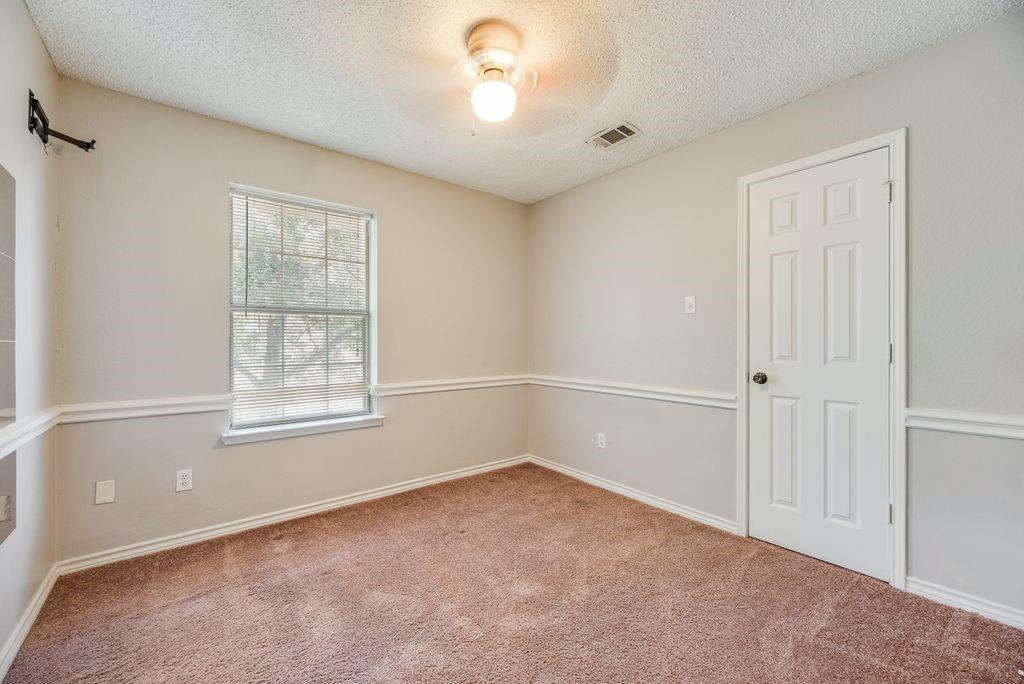5610 Eagle Rock Road Arlington, TX 76017 - Photo 18 of 33 Room featuring light-colored walls with chair rail molding, a neutral tone carpet, and a multi-pane window with blinds
