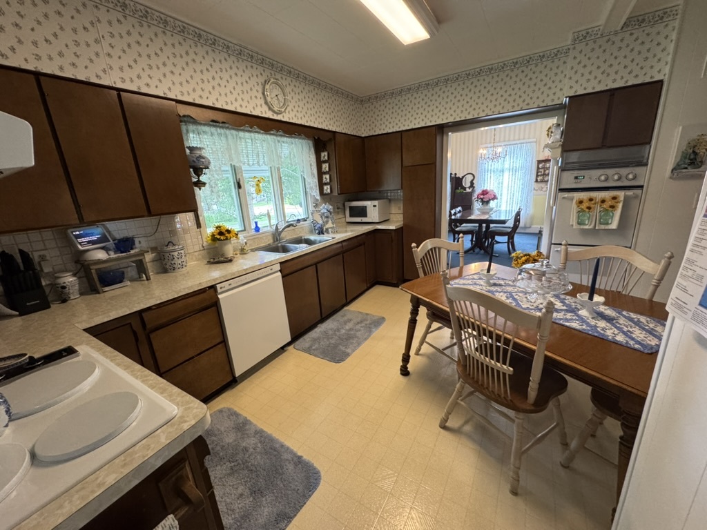 401 West 10th Street Sterling, IL 61081 - Photo 14 of 35 a kitchen with stainless steel appliances kitchen island granite countertop a table chairs and a refrigerator