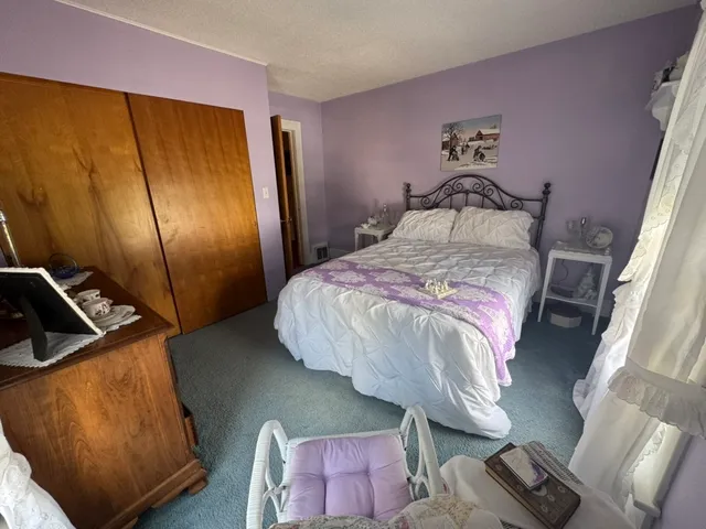 a bed sitting in a bedroom next to a window