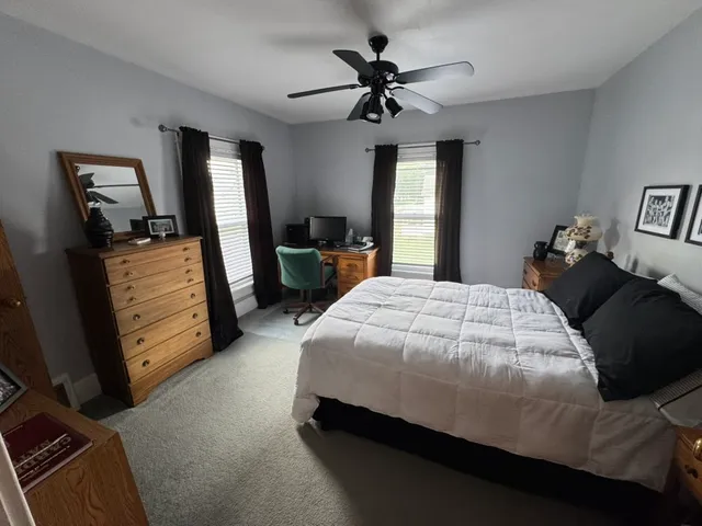 a bedroom with a bed a dresser and flat screen tv
