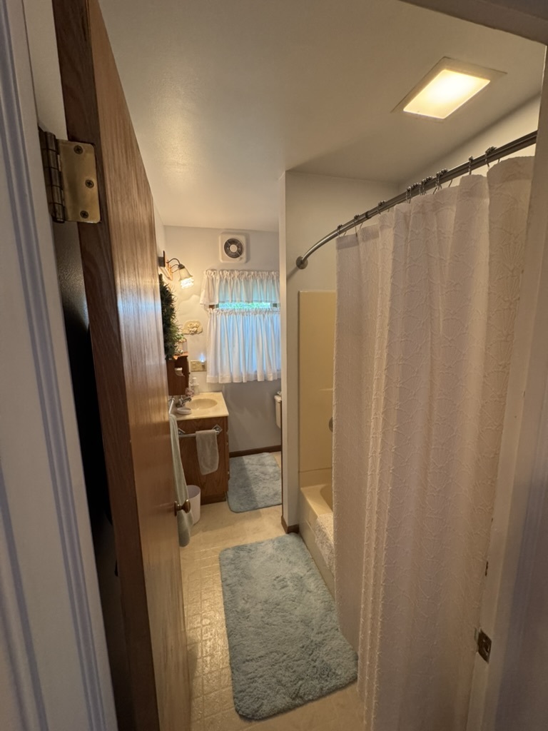401 West 10th Street Sterling, IL 61081 - Photo 29 of 35 a bathroom with a sink a toilet a shower and a mirror
