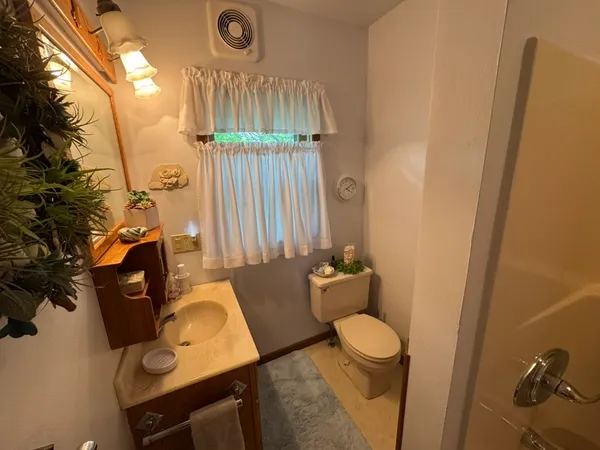 a bathroom with a toilet sink and mirror