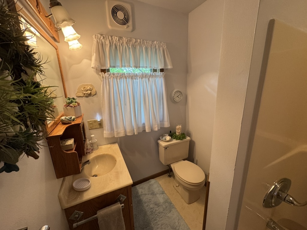 401 West 10th Street Sterling, IL 61081 - Photo 30 of 35 a bathroom with a toilet sink and mirror