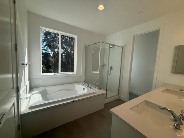 a bathroom with a tub sink and mirror