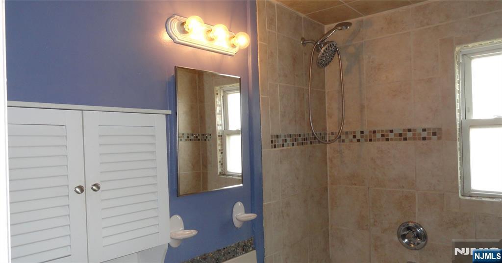 73 B Hastings Avenue, Unit B Rutherford, NJ 07070 - Photo 5 of 6 a bathroom with a shower and a mirror