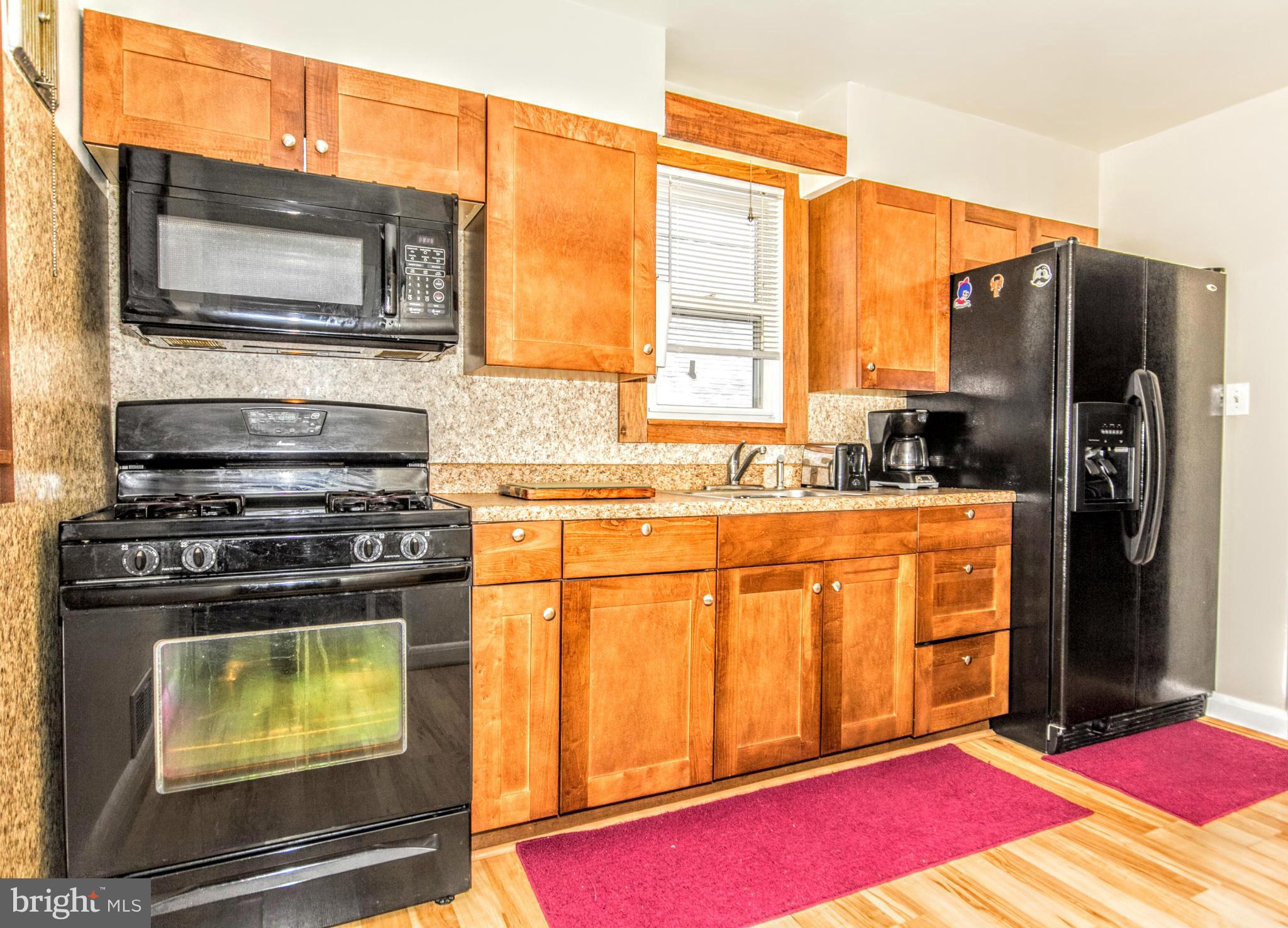 8109 Conduit Road Baltimore, MD 21234 - Photo 14 of 26 a kitchen with stainless steel appliances kitchen island granite countertop a refrigerator a stove top oven and a sink