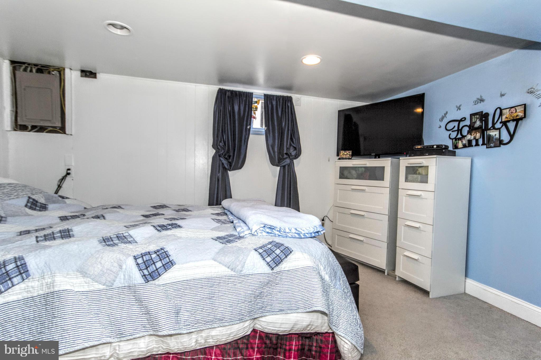 8109 Conduit Road Baltimore, MD 21234 - Photo 22 of 26 a bedroom with a bed and flat screen tv