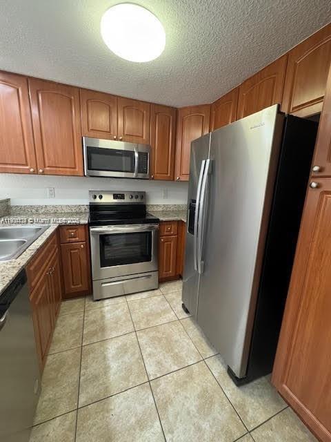 7250 Northwest 174th Terrace, Unit 102 Hialeah, FL 33015 - Photo 11 of 37 a kitchen with stainless steel appliances granite countertop a refrigerator sink and cabinets