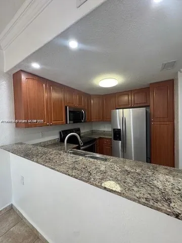 a kitchen with a sink a counter and cabinets