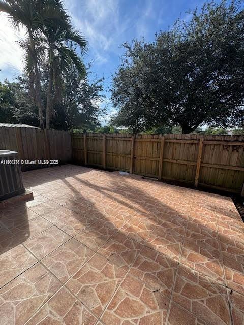 7250 Northwest 174th Terrace, Unit 102 Hialeah, FL 33015 - Photo 19 of 37 a view of backyard with wooden fence and trees