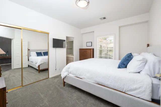 a bedroom with a bed and a large window