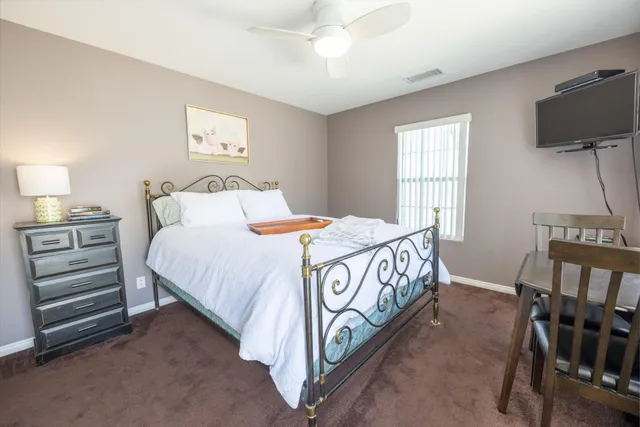 a bedroom with a bed and a flat tv screen on a dresser