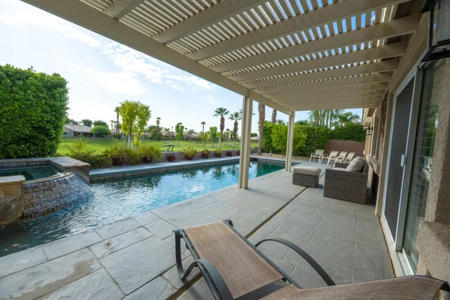 a view of a patio with table and chairs potted plants with floor to ceiling window