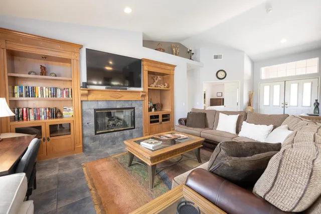 a living room with furniture a flat screen tv and a fireplace