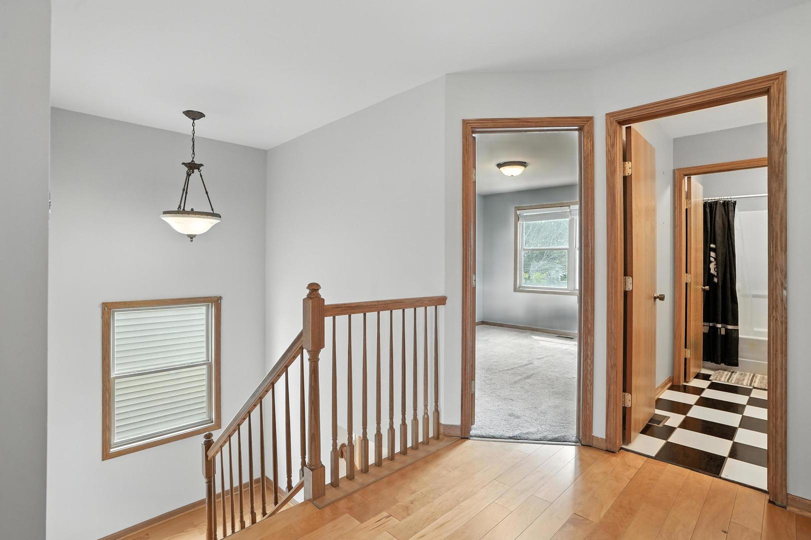 1665 Fox Hound Trail Beecher, IL 60401 - Photo 24 of 34 wooden floor in a hall with a window and a mirror