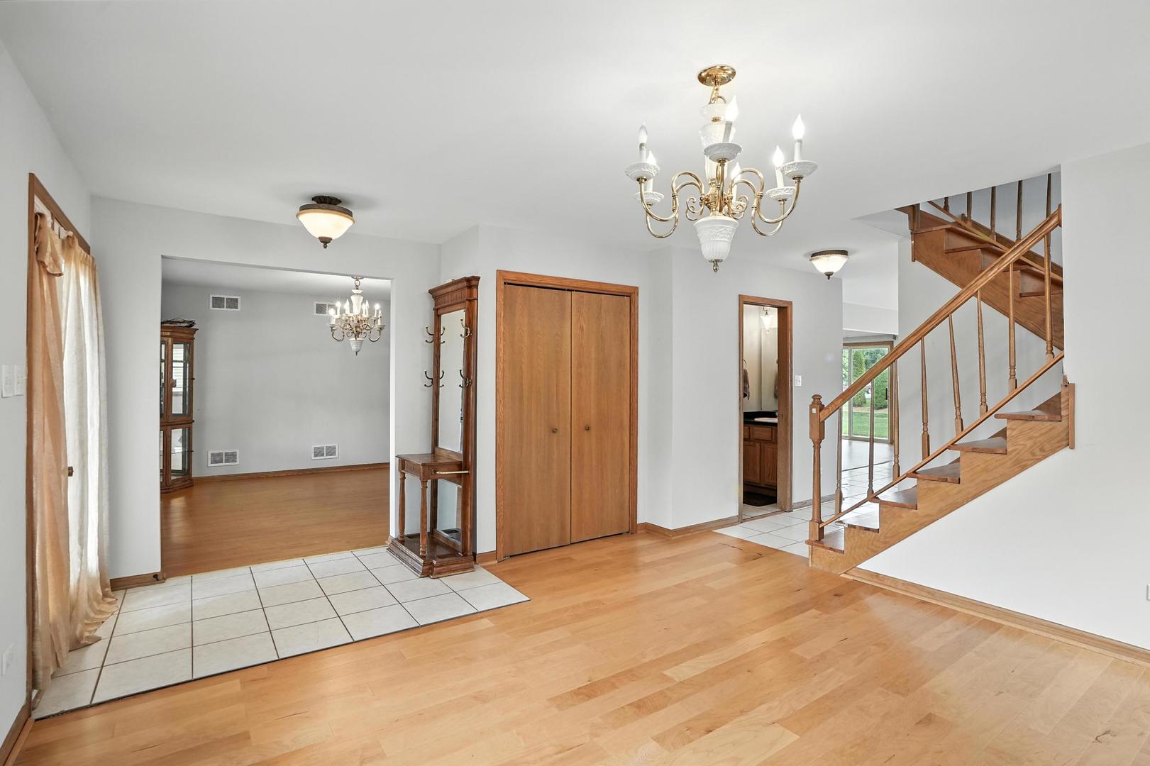 1665 Fox Hound Trail Beecher, IL 60401 - Photo 10 of 34 a view of an entryway with wooden floor and a chandelier