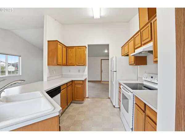 a kitchen with a sink stove top oven and refrigerator