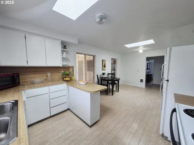 a open kitchen with cabinets stove and white refrigerator