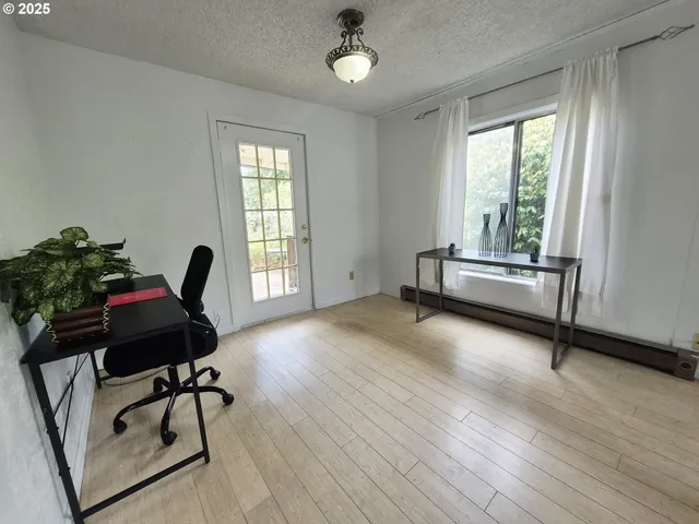 a view of a workspace with furniture and a window