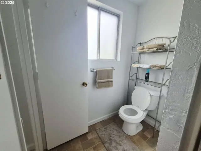 a white toilet sitting next to a bathroom sink and a window