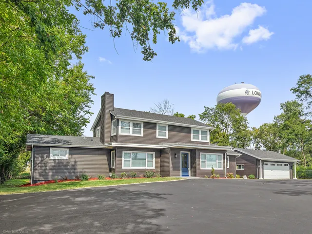 a front view of a house with a yard and potted plants