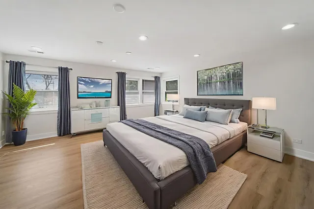 a spacious bedroom with a bed and a cabinets