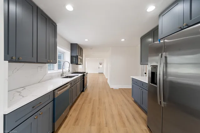 a large kitchen with stainless steel appliances granite countertop a lot of counter space wooden floor and stainless steel appliances