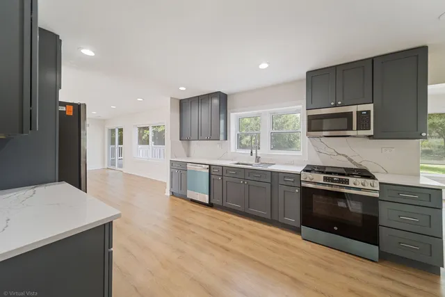 a kitchen with stainless steel appliances kitchen island granite countertop a stove a sink and a refrigerator