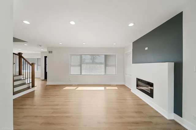 a view of an empty room with a fireplace and a window