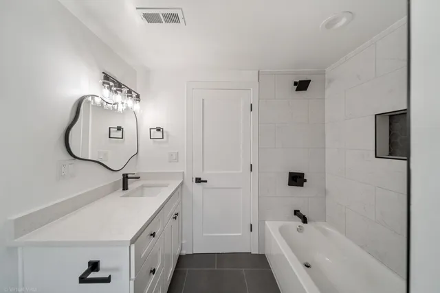 a bathroom with a tub sink and mirror