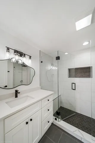 a bathroom with a double vanity sink mirror and shower