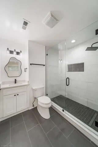a bathroom with a double vanity sink toilet and shower