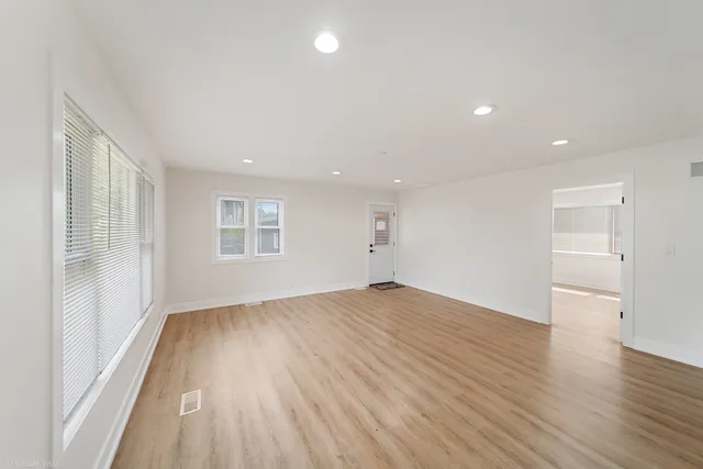 a view of empty room with wooden floor
