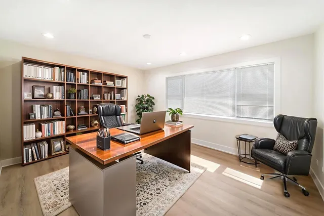 a living room with furniture a bookshelf and a window