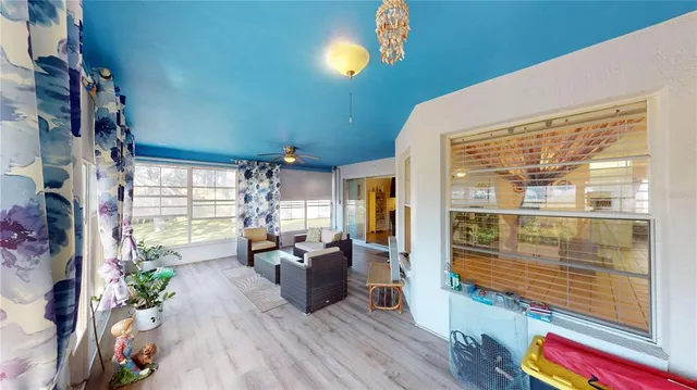 a living room with furniture floor to ceiling window and wooden floor