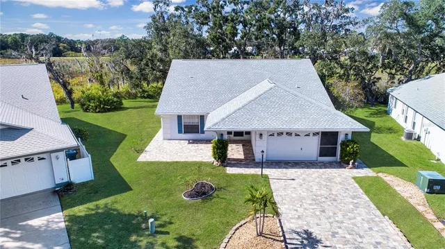 an aerial view of a house with swimming pool and outdoor seating