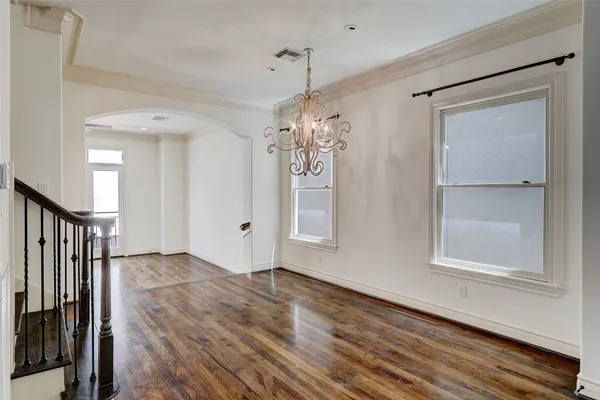 a view of a room with wooden floor entryway and windows