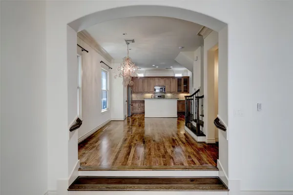 a living room with kitchen view and wooden floor