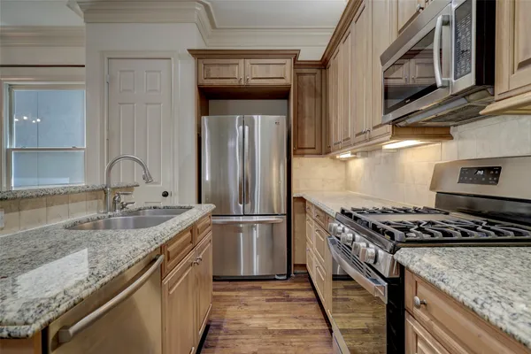 a kitchen with stainless steel appliances granite countertop a sink and a stove