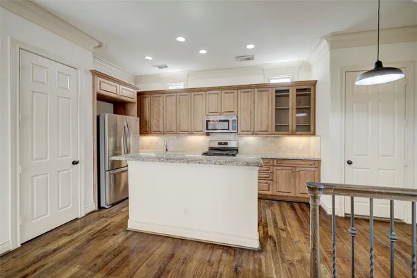 a kitchen with stainless steel appliances granite countertop a refrigerator a sink and a stove