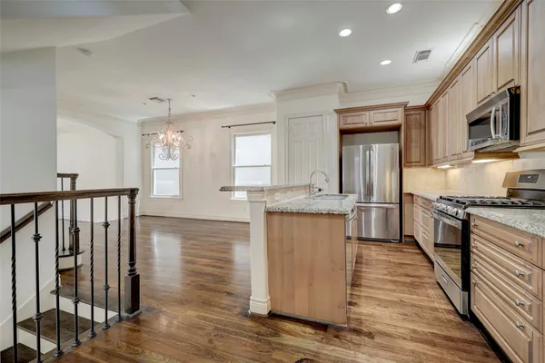 a kitchen with stainless steel appliances granite countertop a refrigerator and a stove top oven