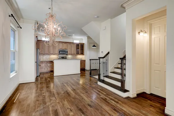 a view of a kitchen with wooden floor and stainless steel appliances